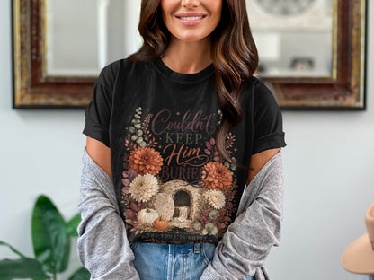 Black t-shirt with floral design, tomb, and text "Couldn't Keep Him Buried".
