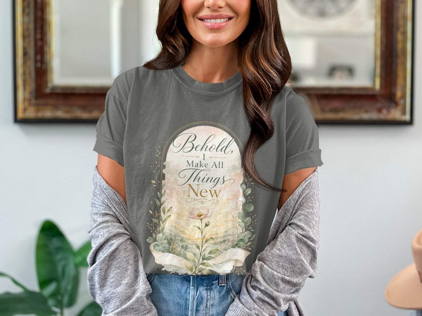 Graphic t-shirt with text "Behold, I Make All Things New" and floral design.