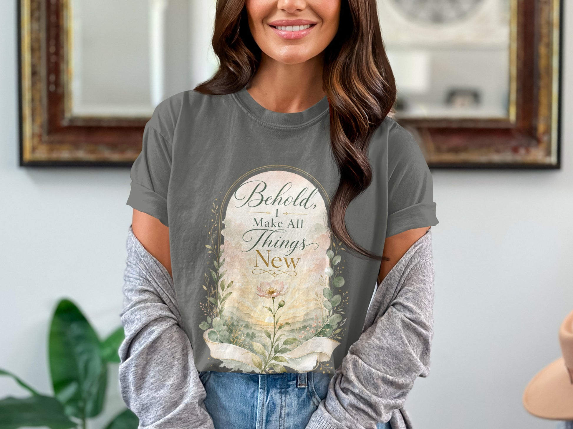 Graphic t-shirt with text "Behold, I Make All Things New" and floral design.