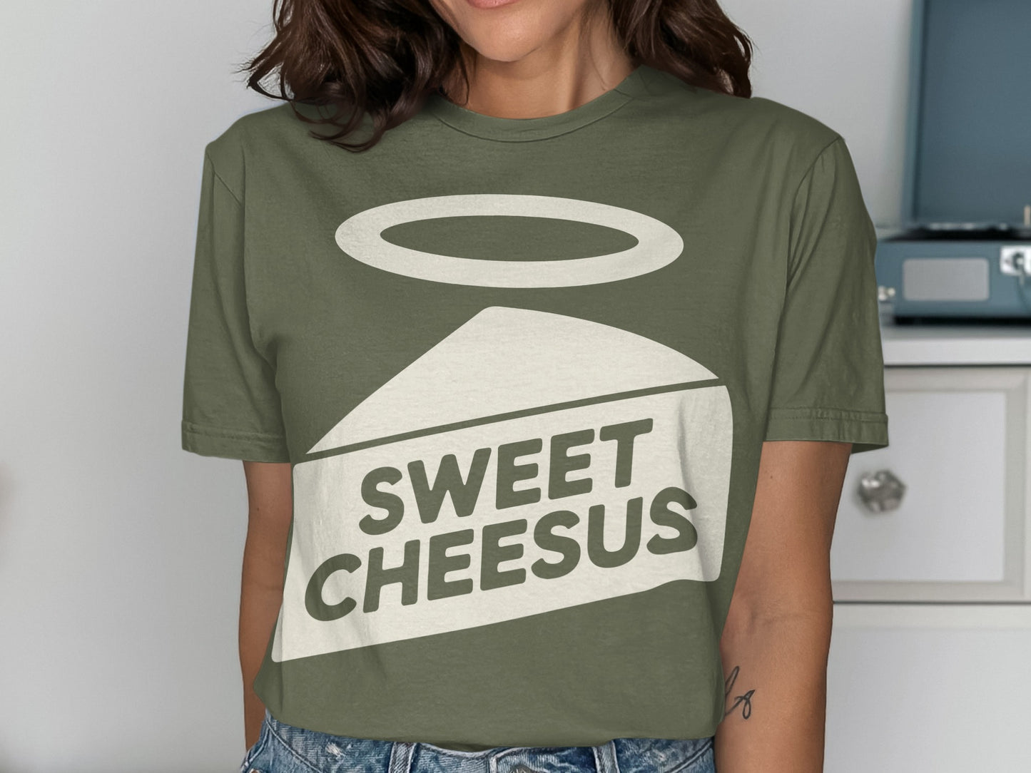 Green t-shirt with "Sweet Cheesus" text and a slice of cheese with halo.