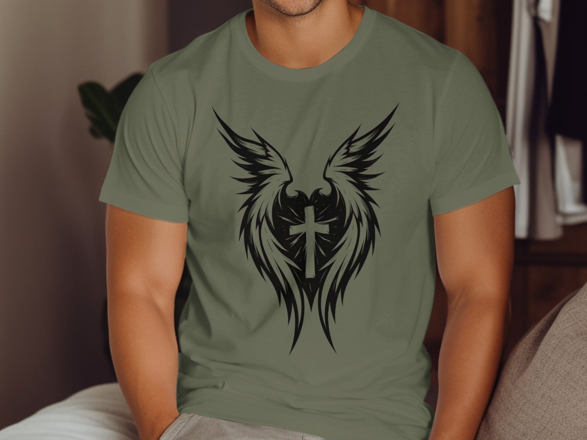 Green t-shirt with black tribal cross and wing graphic.