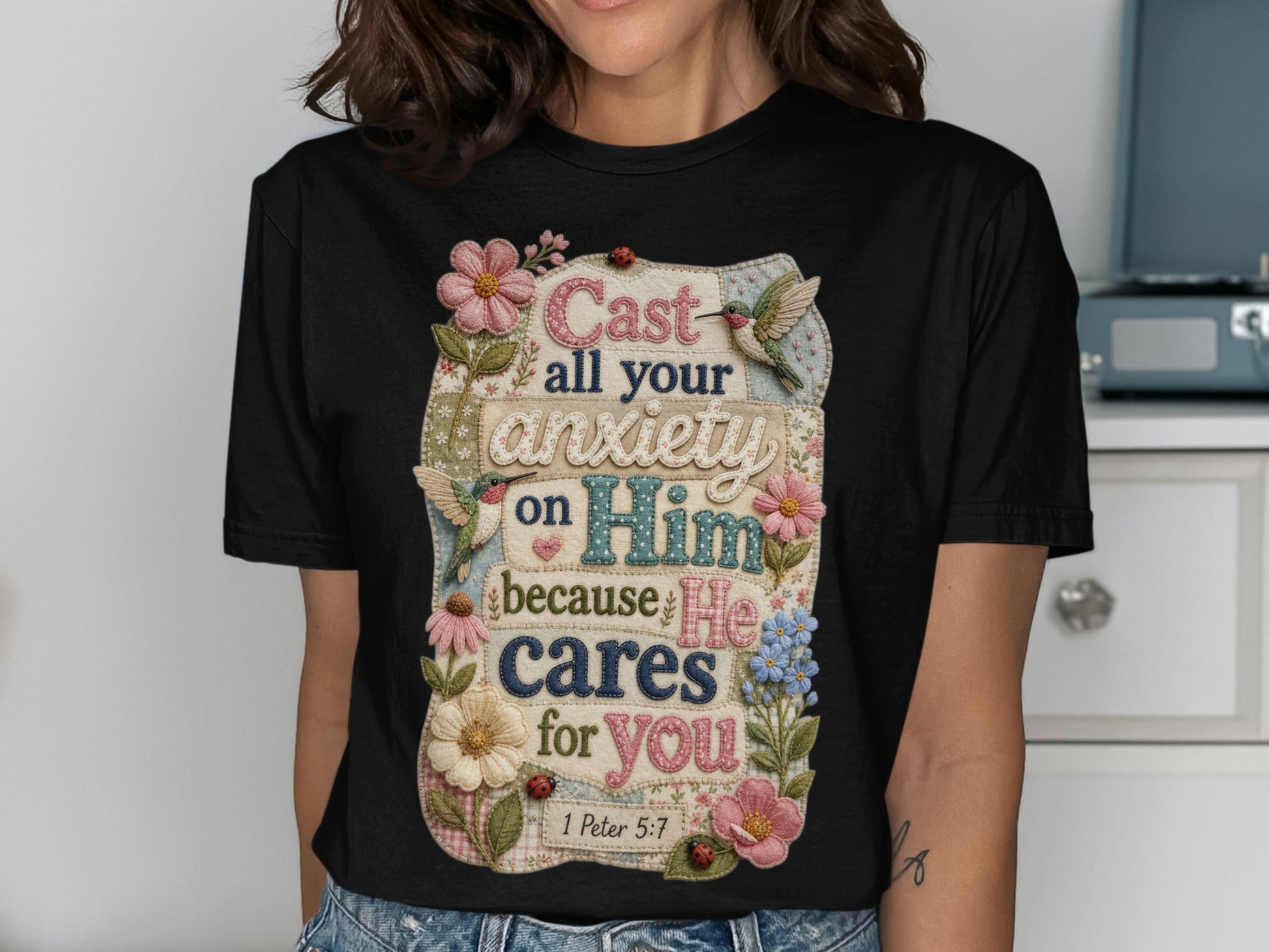 T-shirt with "Cast all your anxiety on Him because He cares for you 1 Peter 5:7" text and floral accents.