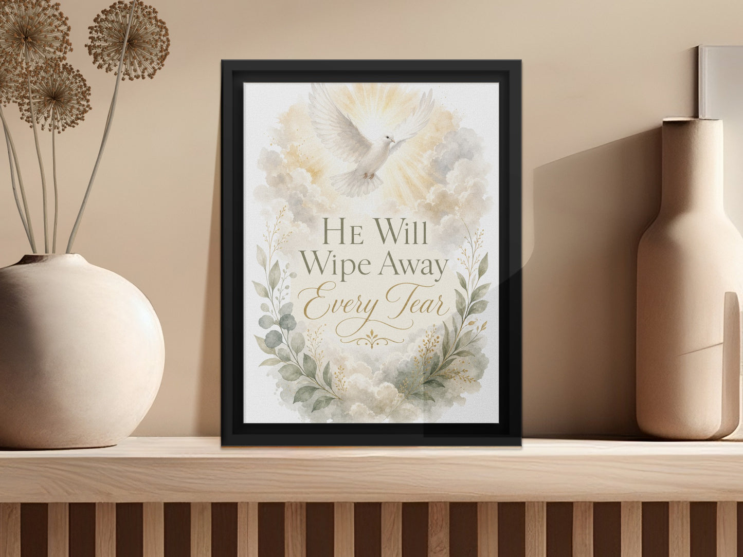 Framed artwork with dove and text "He Will Wipe Away Every Tear" amidst clouds.