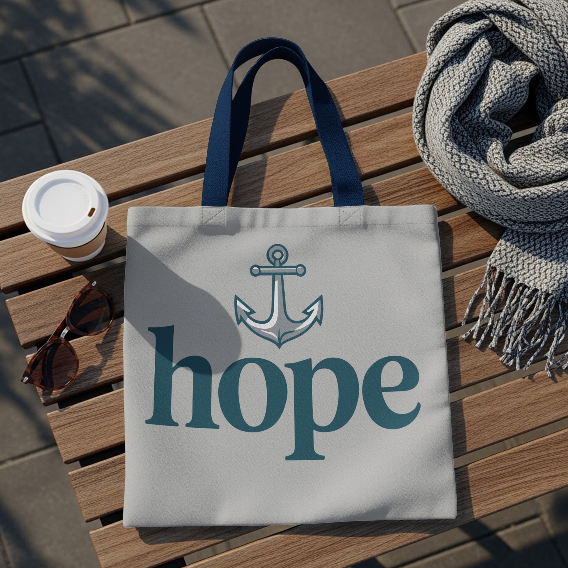Light gray tote bag with blue anchor and "hope" text, on a wooden bench.