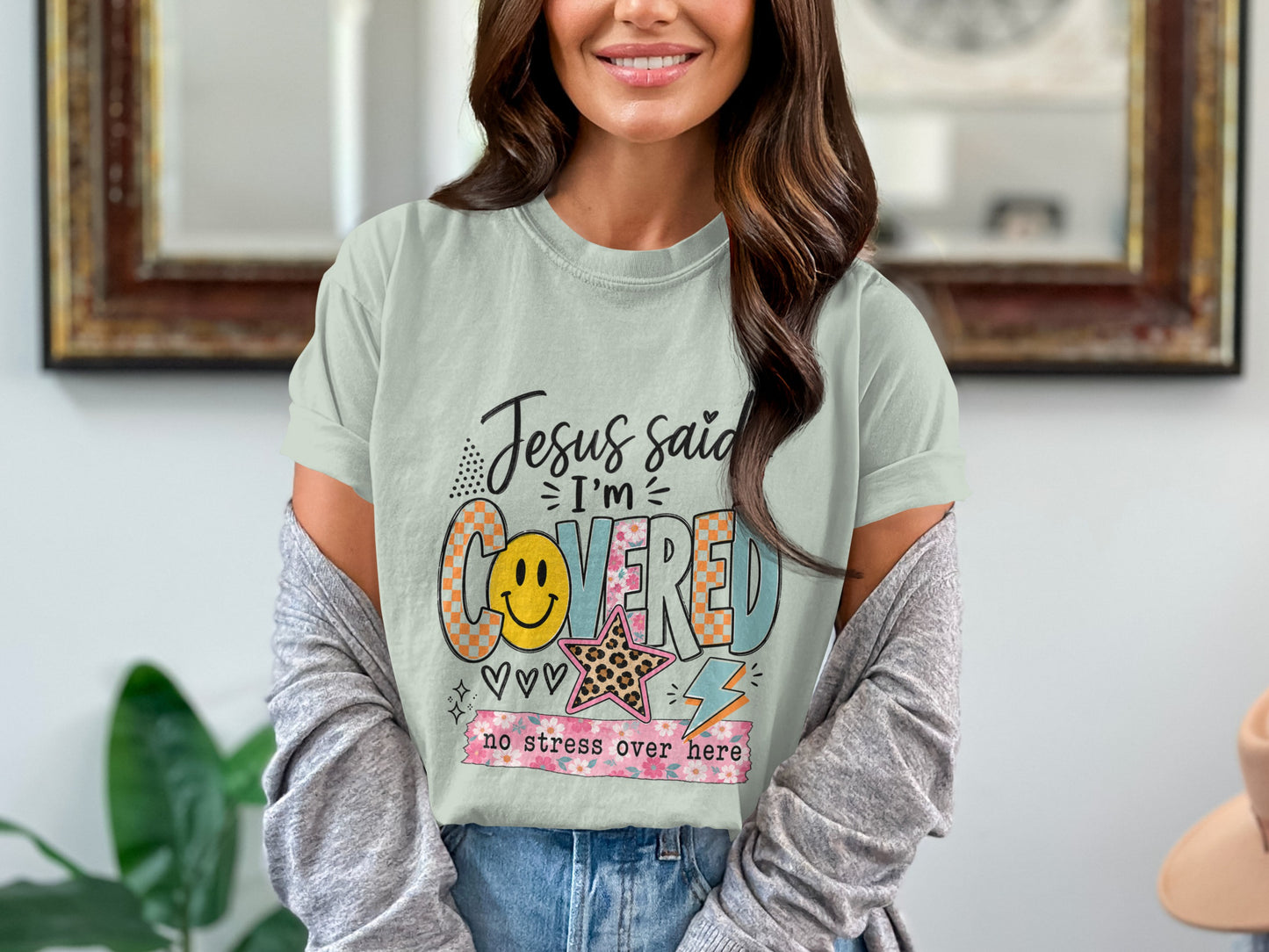 Light blue t-shirt with "Jesus said I'm covered no stress over here" graphic.
