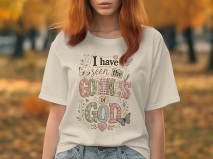 White t-shirt with "I have seen the goodness of God" in decorative lettering and floral accents.