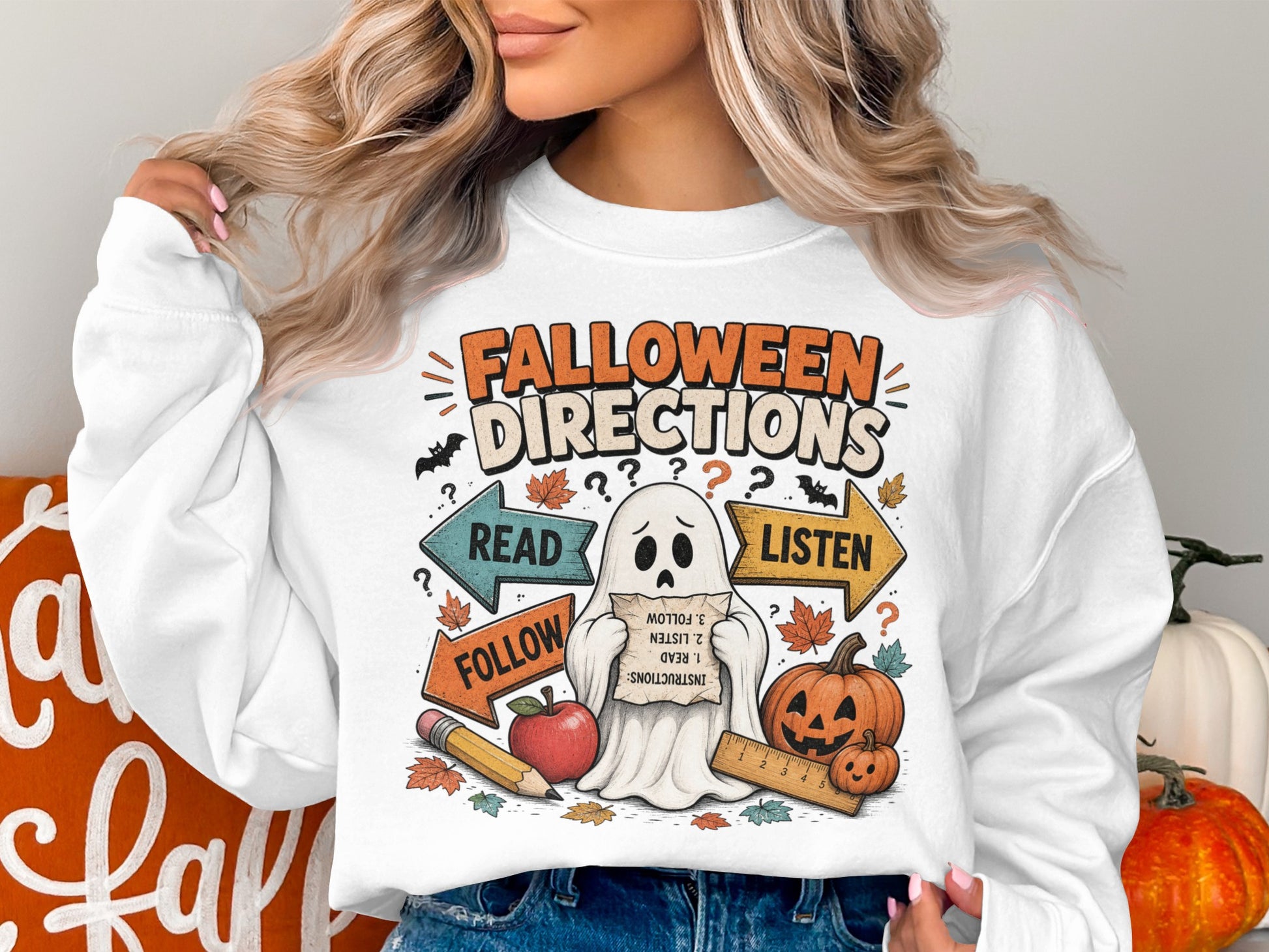 Halloween directions with a ghost, pumpkins, and autumn leaves on a white sweatshirt.