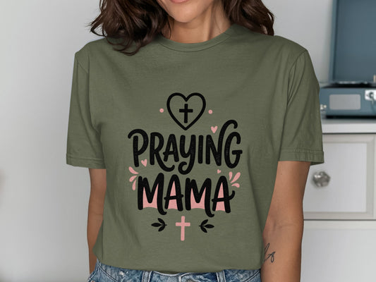 Olive green t-shirt with "Praying Mama" text and heart and cross graphics.