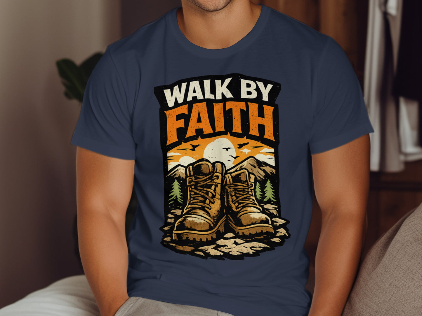 Hiking boots and sunset graphic on a navy t-shirt with "WALK BY FAITH" text.