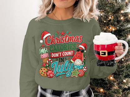 Green Christmas sweatshirt with "Christmas Calories Don't Count In July" text and festive treats.