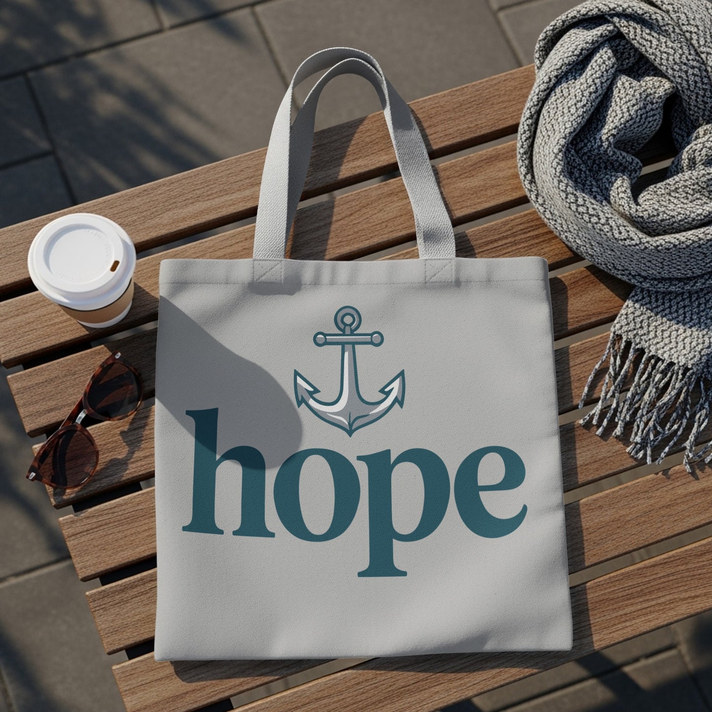 Light grey tote bag with anchor graphic and "hope" text on a wooden bench.
