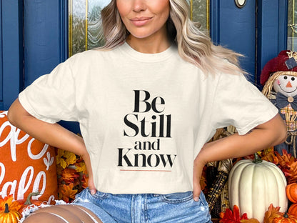 Cream t-shirt with "Be Still and Know" text, worn by a woman.