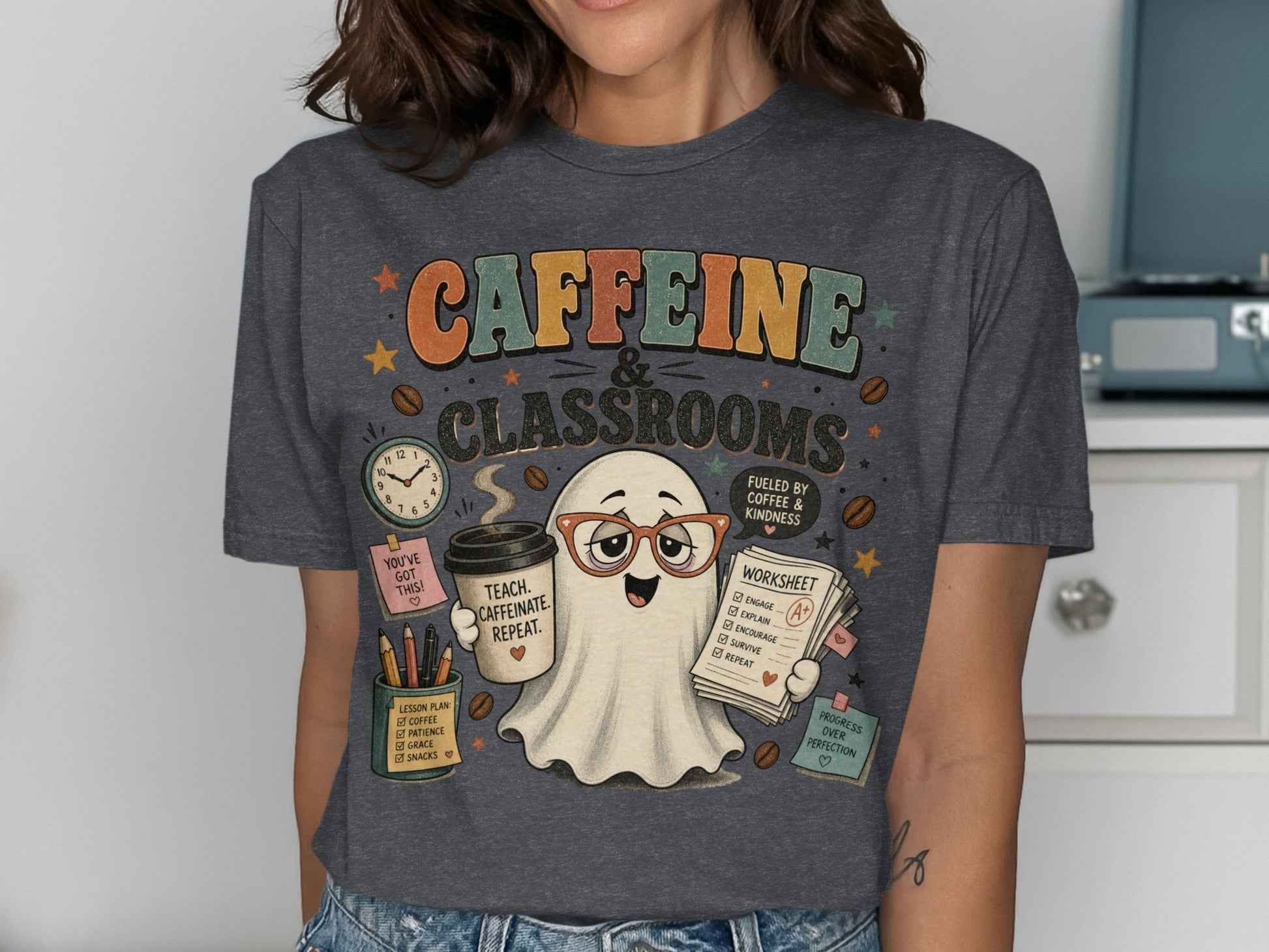 Retro ghost with glasses holds coffee and worksheet on shirt that says "CAFFEINE & CLASSROOMS".