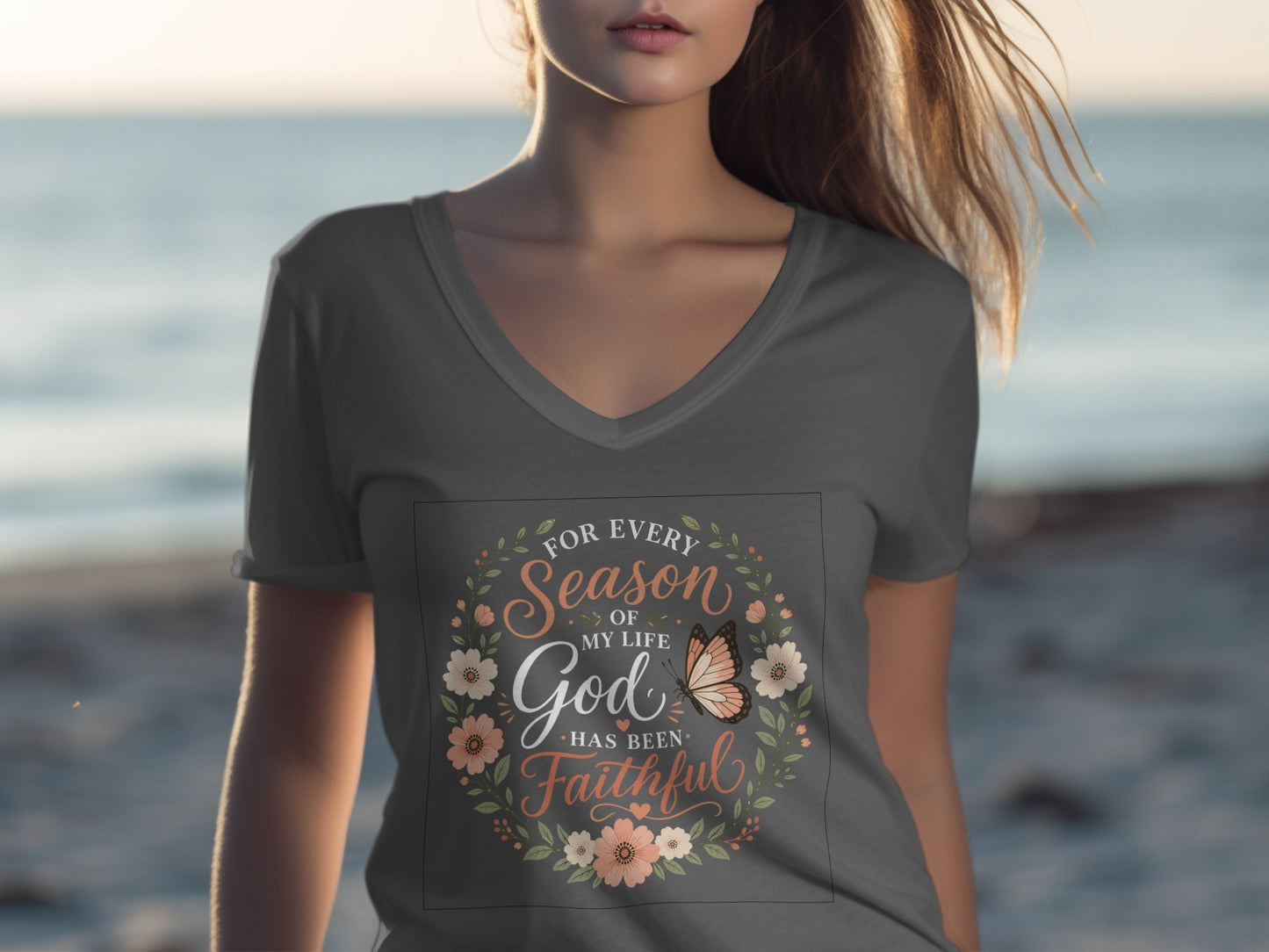 Woman wearing a gray v-neck t-shirt with "For Every Season of My Life God Has Been Faithful" text.