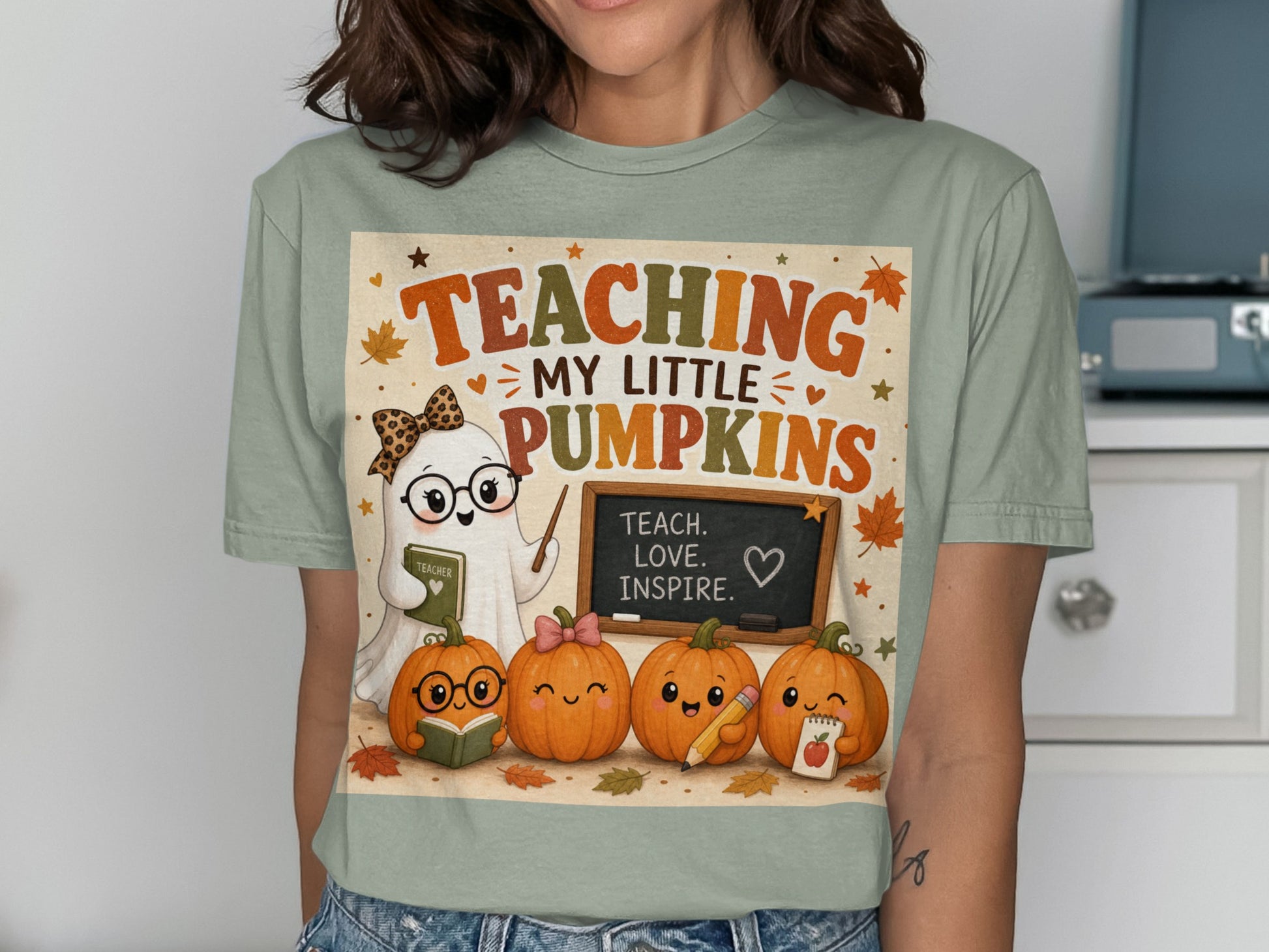 Ghost teacher with pumpkins on shirt saying "TEACHING MY LITTLE PUMPKINS".