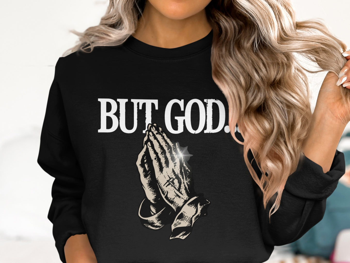Black sweatshirt with praying hands graphic and text "BUT GOD."