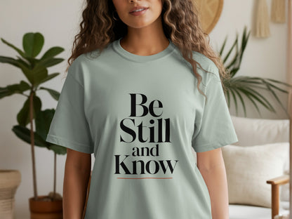 Light green t-shirt with black text "Be Still and Know".