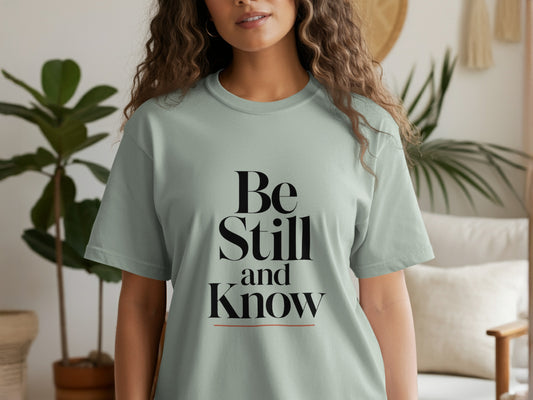Light green t-shirt with black text "Be Still and Know".