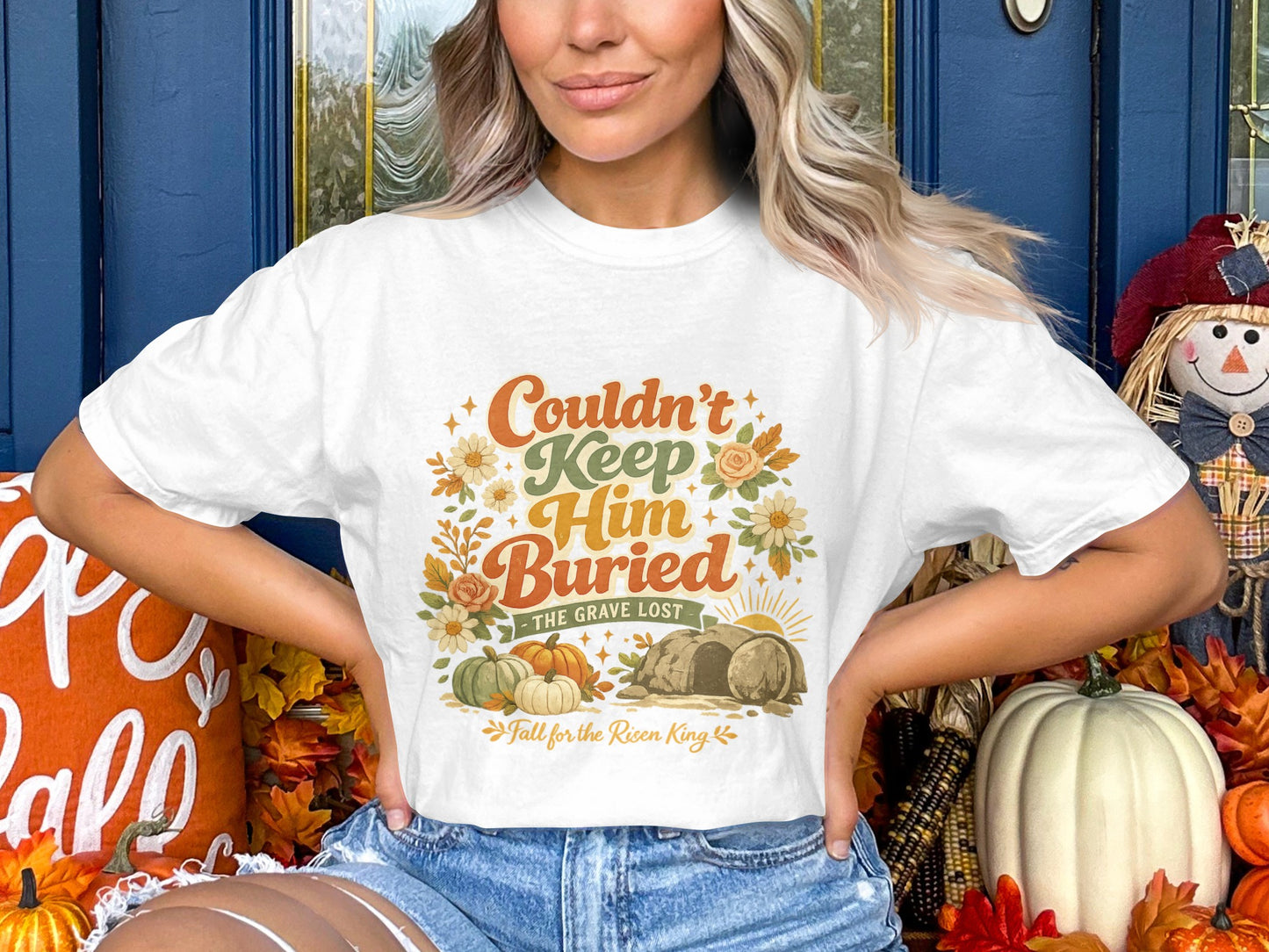 White t-shirt with "Couldn't Keep Him Buried The Grave Lost" text and fall graphics.