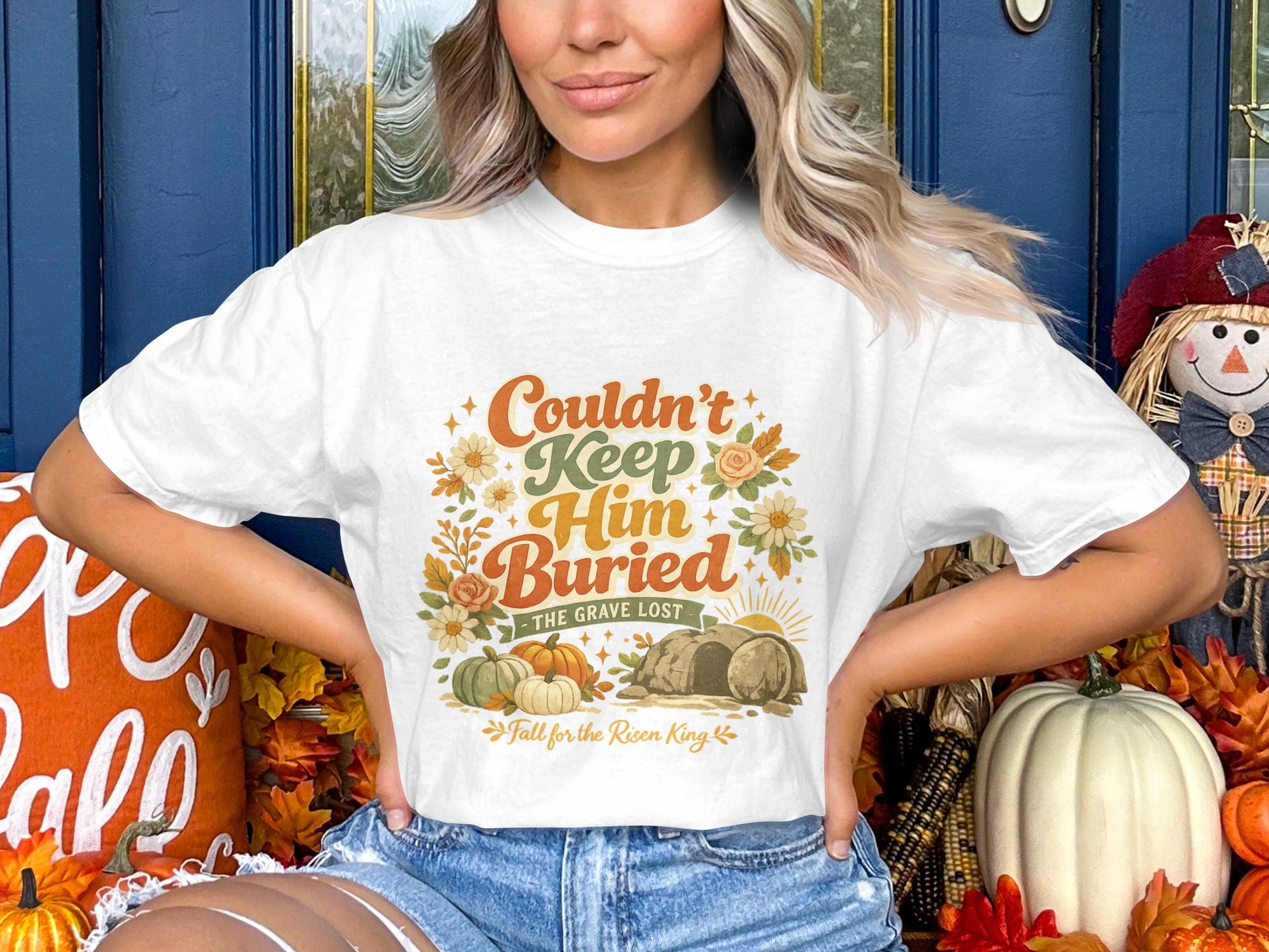 White t-shirt with "Couldn't Keep Him Buried The Grave Lost" text and fall graphics.