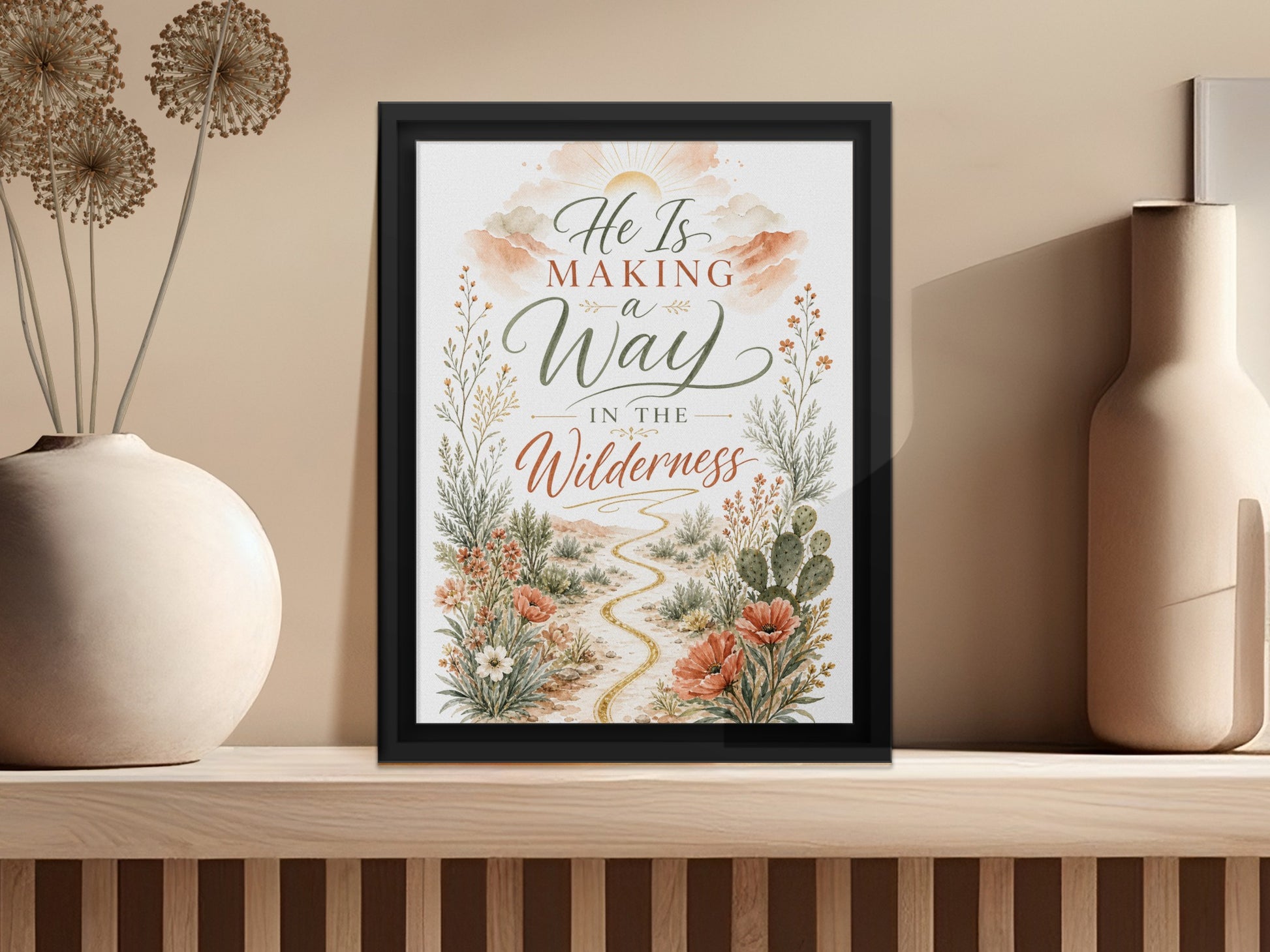 Framed art with "He Is Making a Way in the Wilderness" text and desert flora.