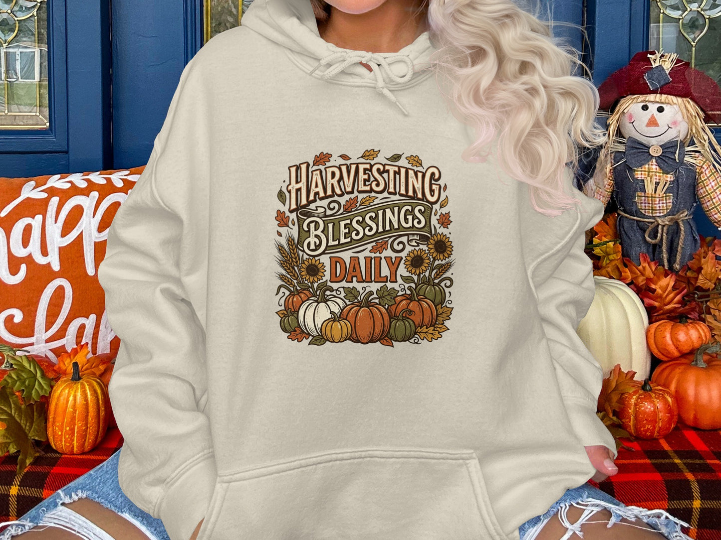 Cream hoodie with "Harvesting Blessings Daily" graphic featuring pumpkins and sunflowers.