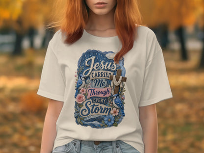 White t-shirt with Jesus carried me through every storm text and floral design.