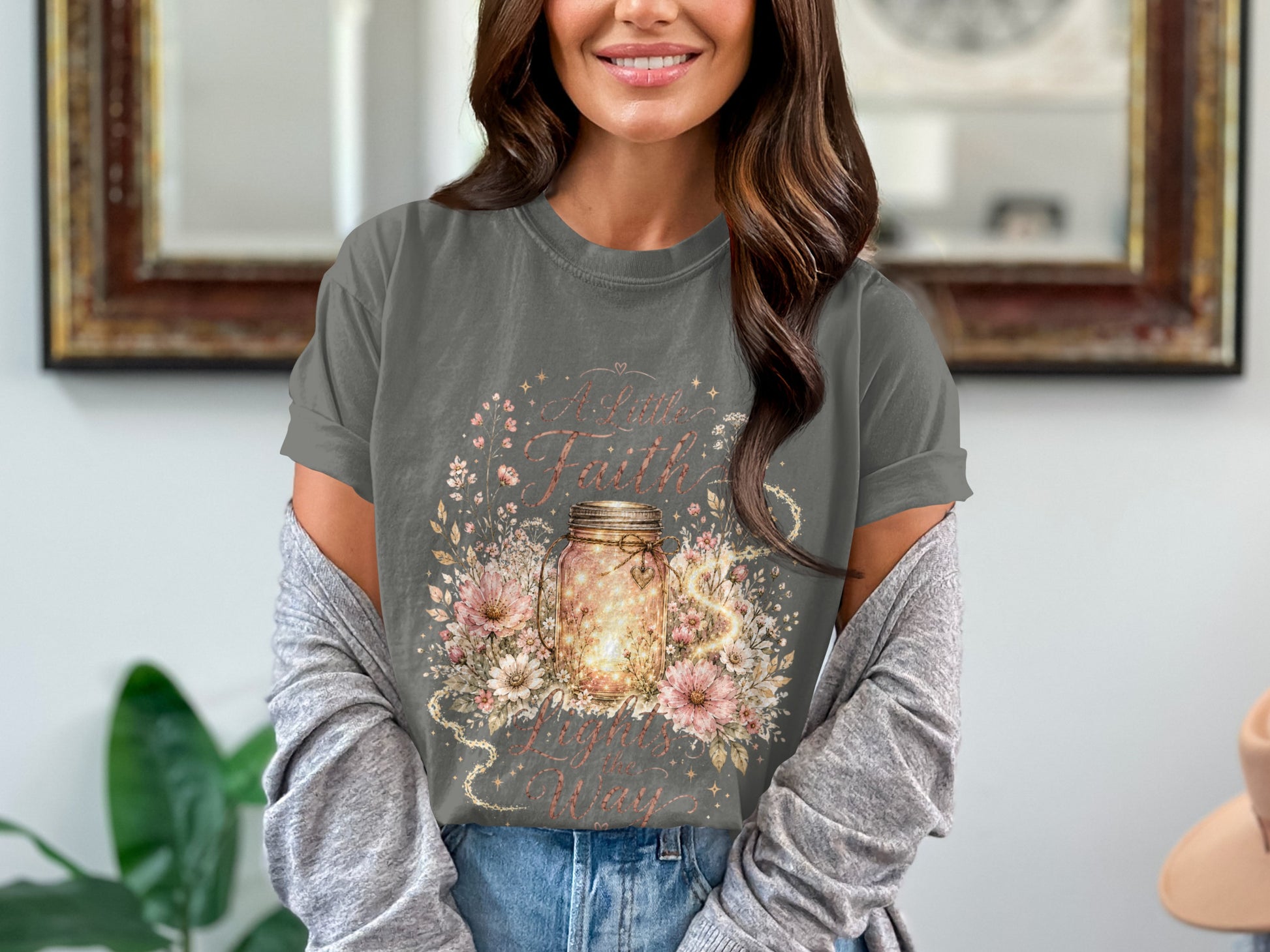 Dark grey t-shirt with a floral design and mason jar with lights, text "A Little Faith Lights the Way".