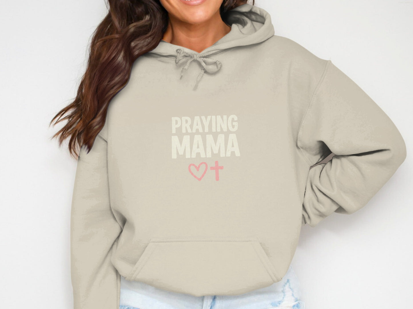Beige hoodie with "PRAYING MAMA" text and heart and cross graphic.