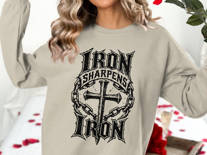 Cream sweatshirt with "Iron Sharpens Iron" text and cross with chains graphic.