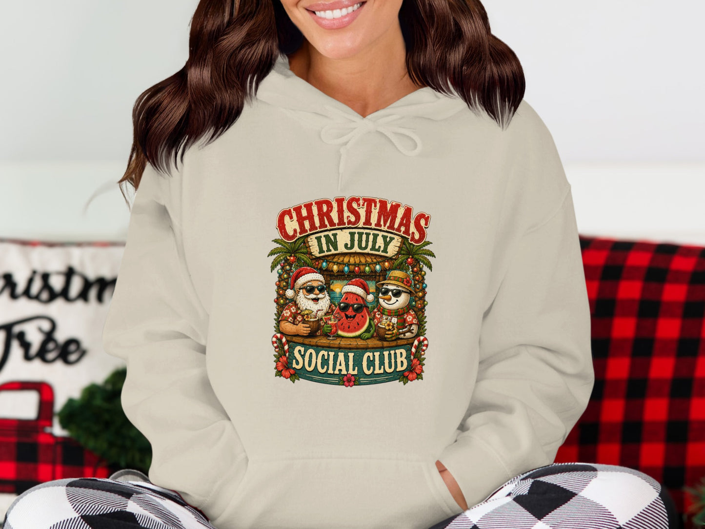 Cream hoodie with "Christmas in July Social Club" graphic featuring Santa, snowman, and watermelon.