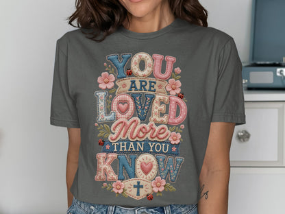 T-shirt with "YOU ARE LOVED MORE THAN YOU KNOW" in patchwork lettering.