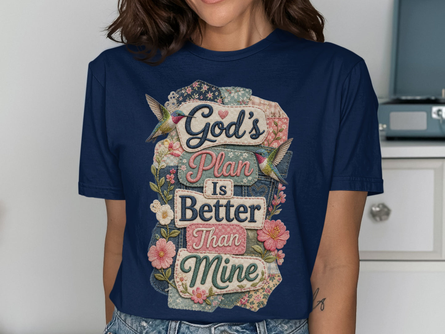 Navy t-shirt with "God's Plan is Better Than Mine" floral and hummingbird design.
