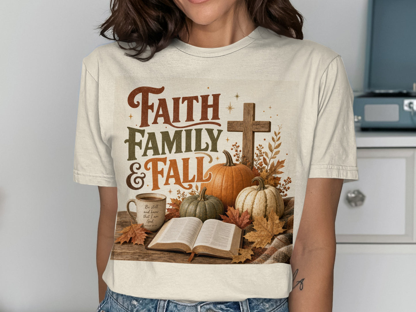 Cream shirt with "Faith Family & Fall" text, pumpkins, cross, book, and mug.