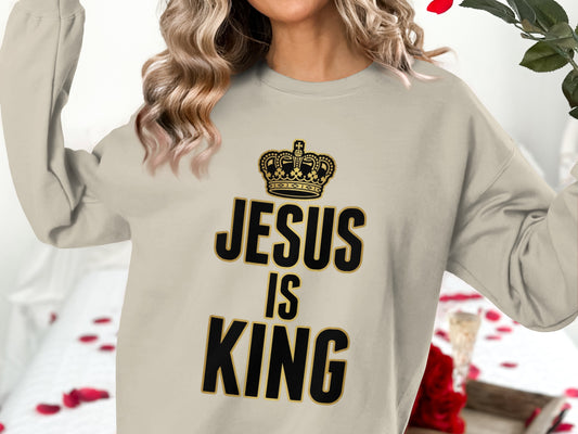 Cream sweatshirt with "Jesus is King" text and a crown logo.