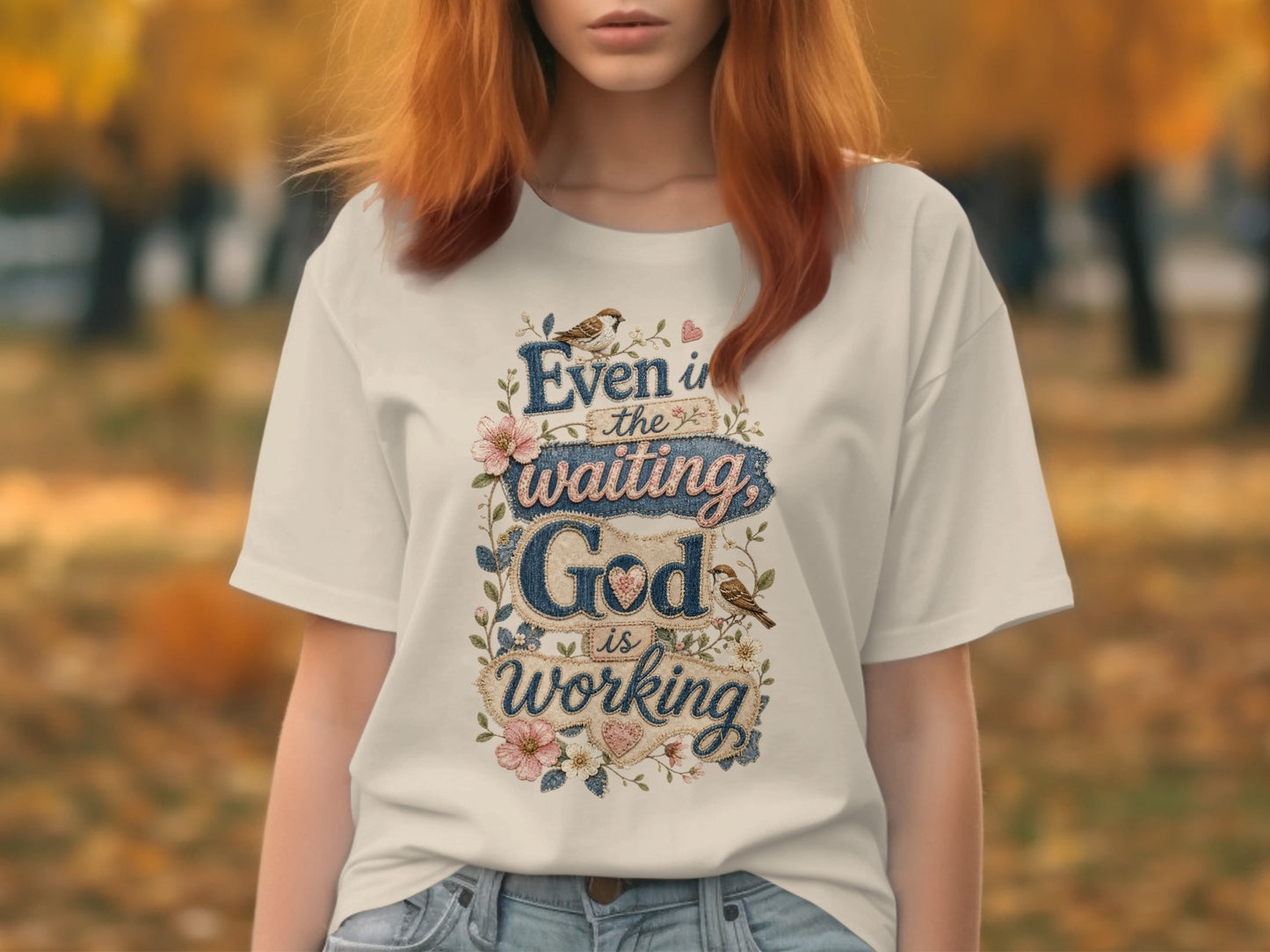 White t-shirt with "Even in the waiting God is working" text and floral accents.
