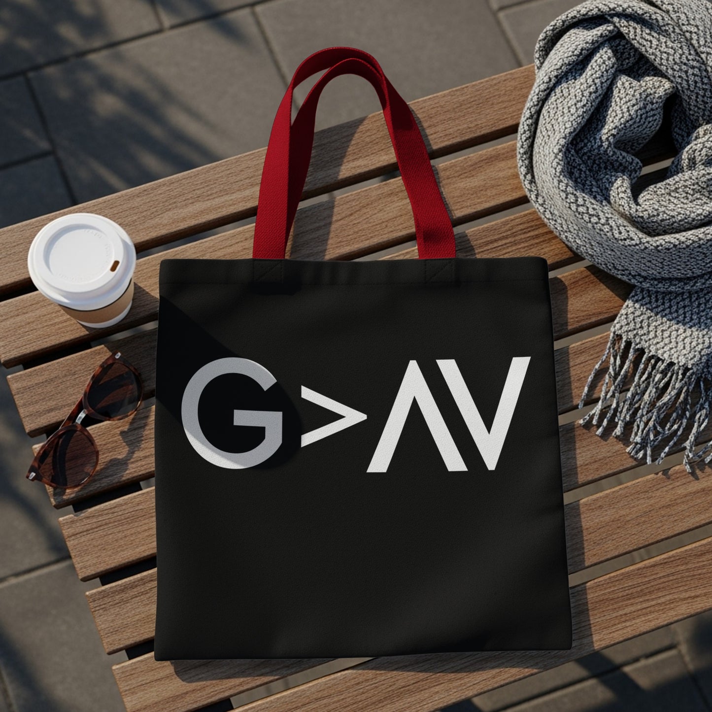 Black tote bag with red handles, featuring white text "G>AV"