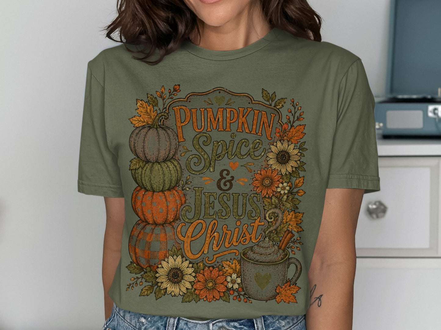 Olive green t-shirt with "Pumpkin Spice & Jesus Christ" text and fall foliage.