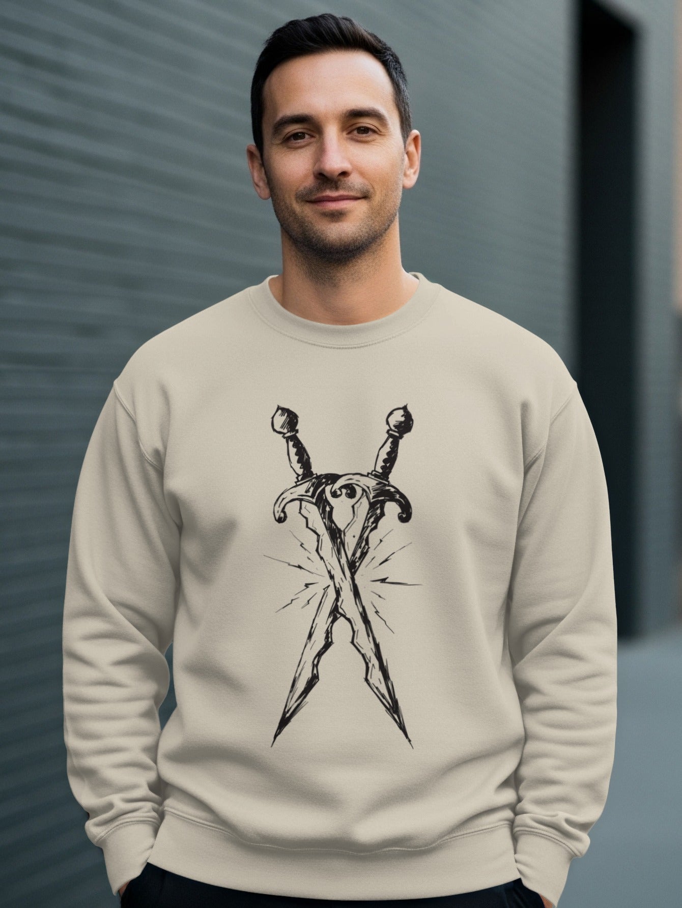 Man wearing a tan sweatshirt with crossed swords graphic design.