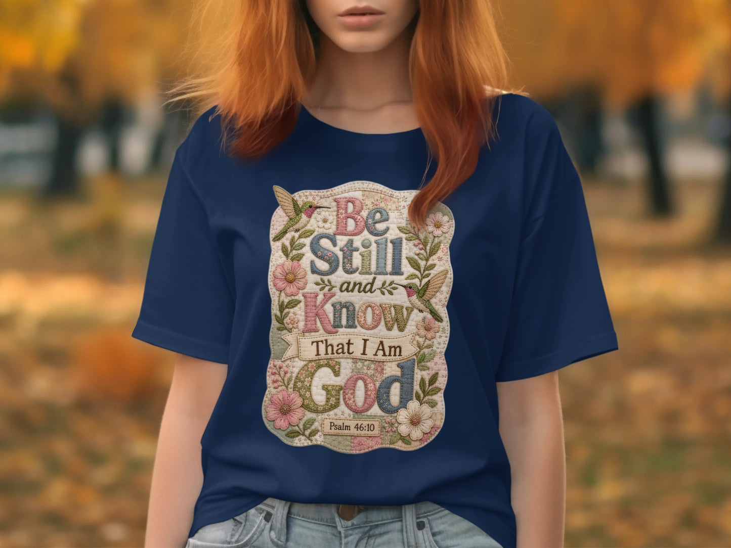 Navy t-shirt with floral design and "Be Still and Know that I am God" text.