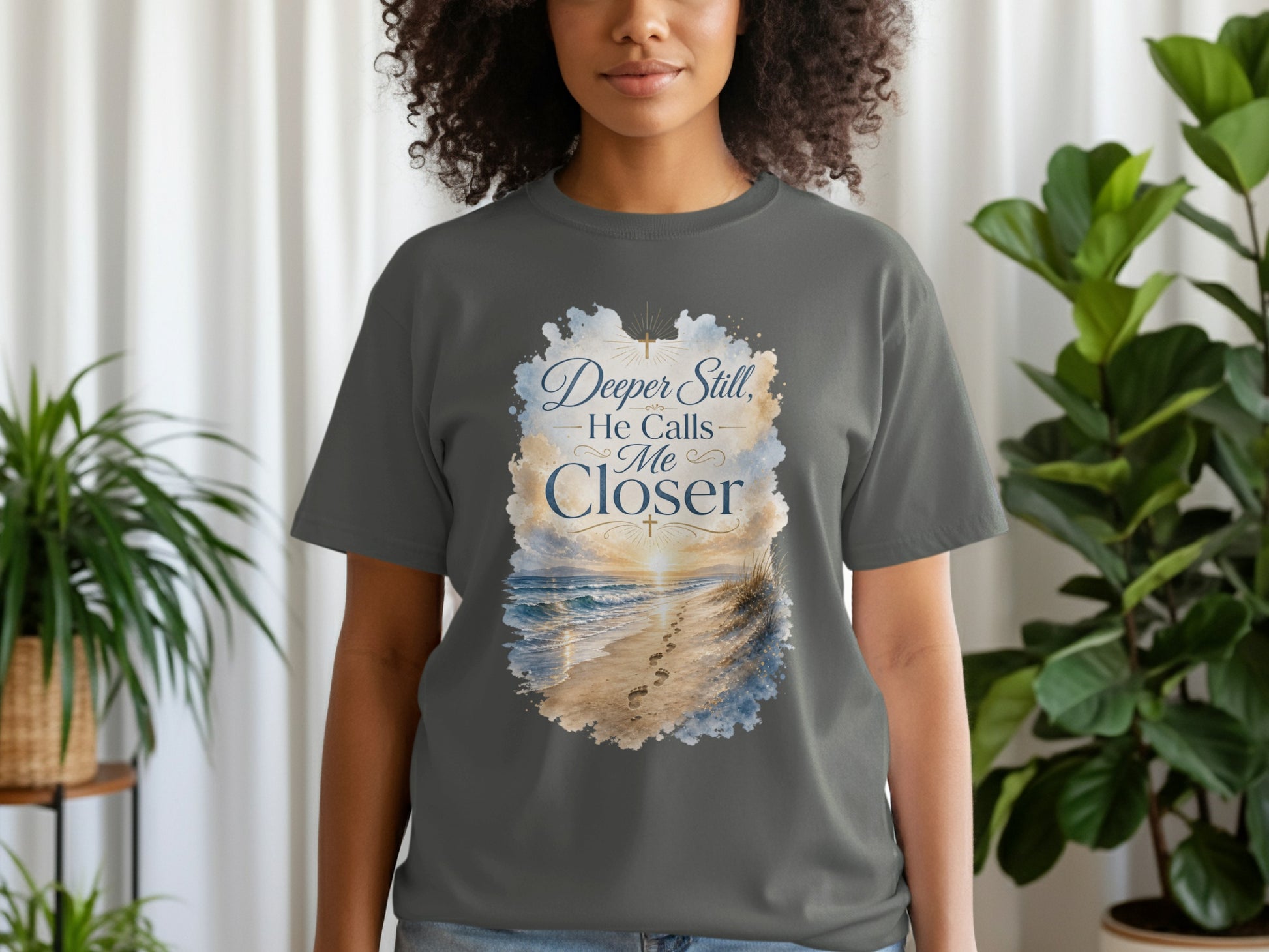 Dark gray t-shirt with "Deeper Still, He Calls Me Closer" and beach design.