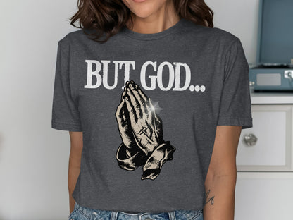 Dark gray t-shirt with "BUT GOD..." and praying hands graphic.