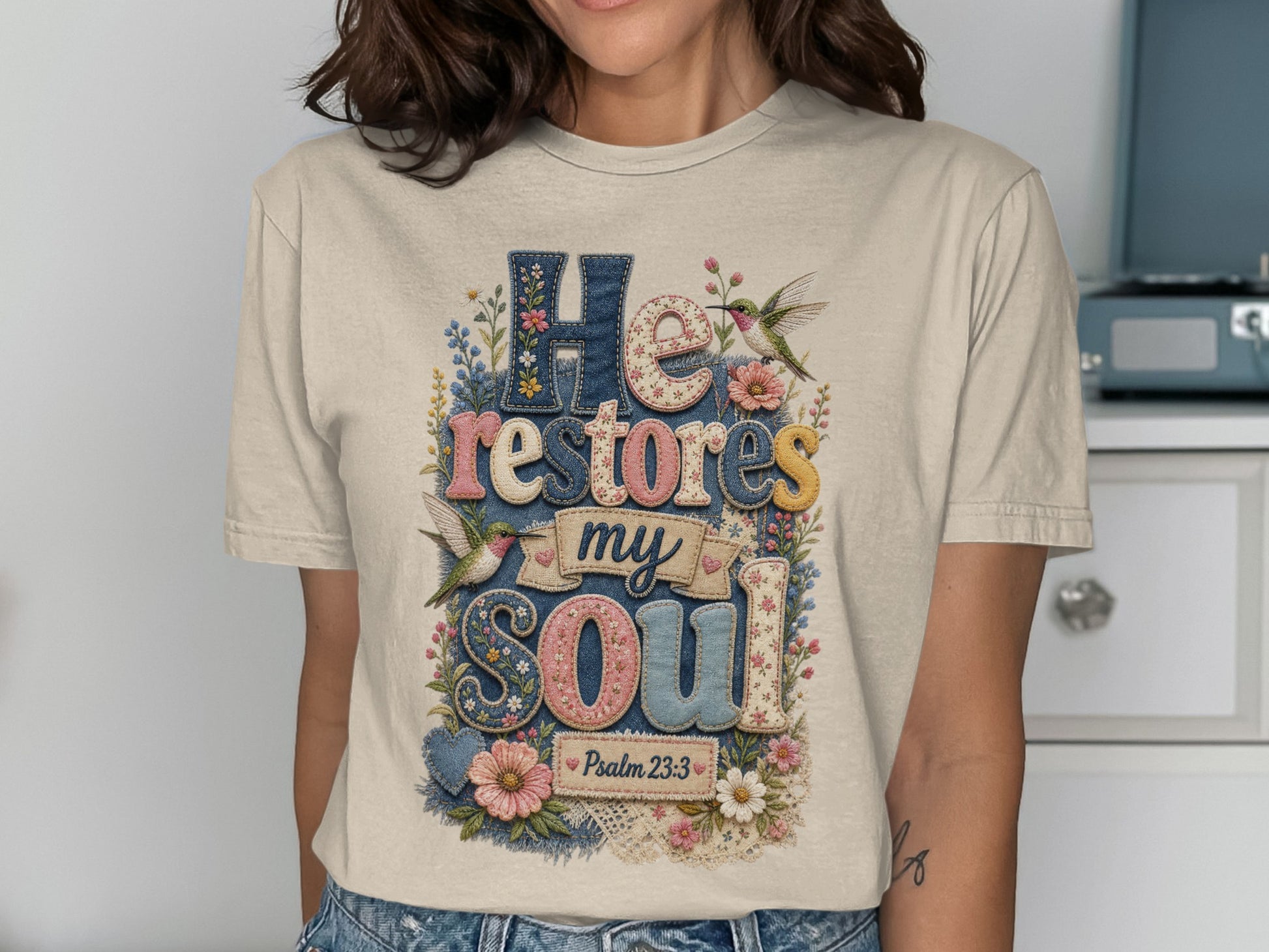T-shirt with "He restores my soul" and floral hummingbird designs.