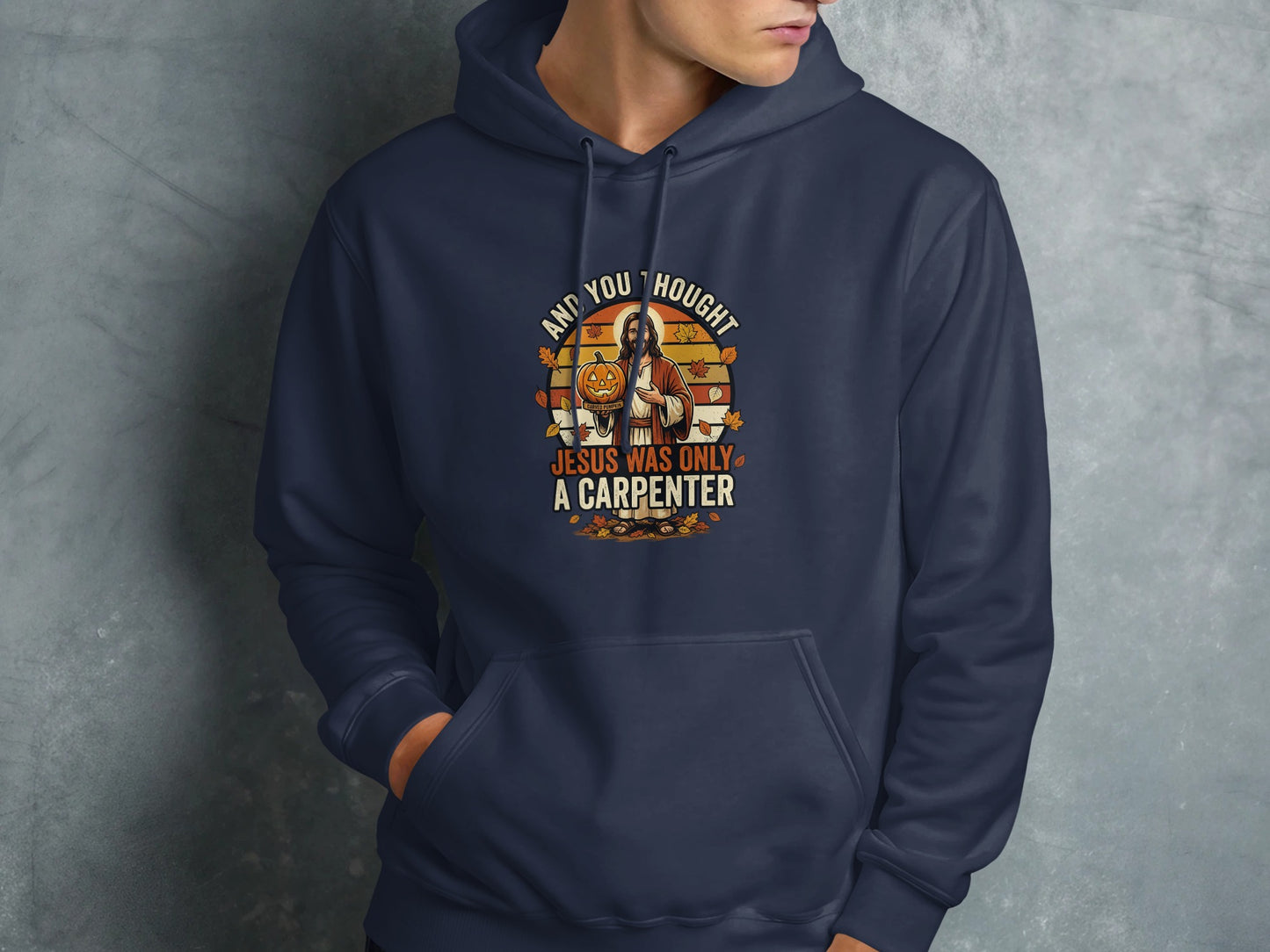 Navy hoodie with "And you thought Jesus was only a carpenter" text and illustration.