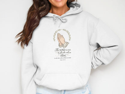 White hooded sweatshirt with praying hands graphic and Psalm 145:18 scripture.