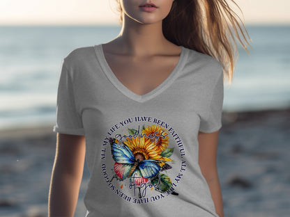Woman in gray t-shirt with butterfly, sunflower, and text design.