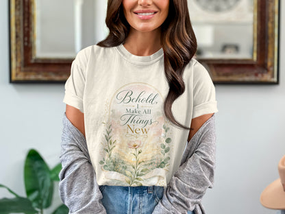 Cream t-shirt with watercolor floral design and text "Behold, I Make All Things New".