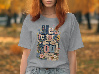 Grey t-shirt with floral "He restores my soul" text, Psalm 23:3.