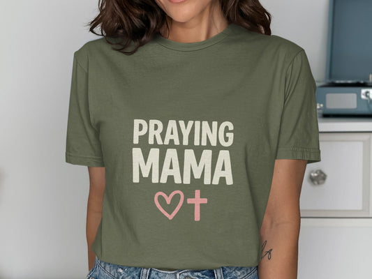 Olive green t-shirt with "PRAYING MAMA" and a pink cross with a heart.