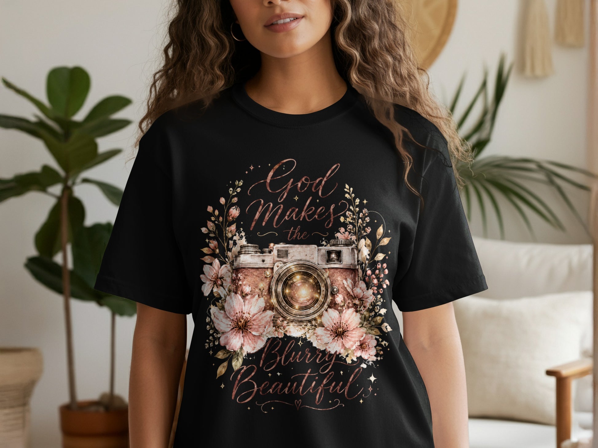 Black t-shirt featuring a floral camera design with text "God Makes the Blurry Beautiful."